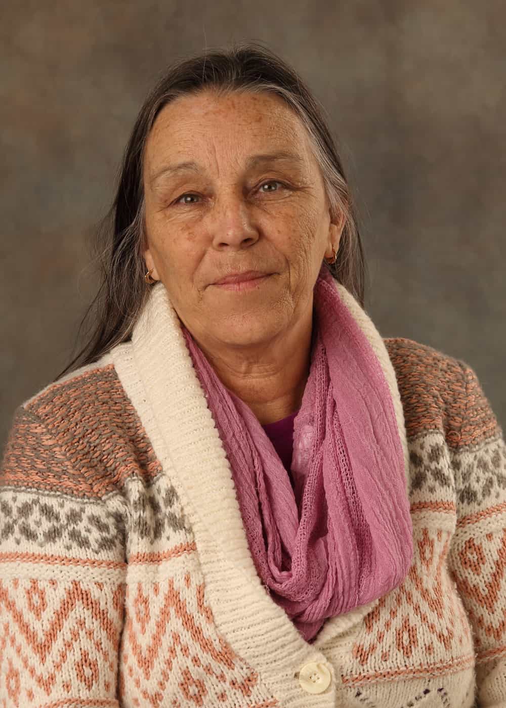 Photo of Financial and Case Manager Louise Russell. She is a Caucasian woman with long dark hair and brown eyes. She is wearing a patterned sweater with a pink scarf.