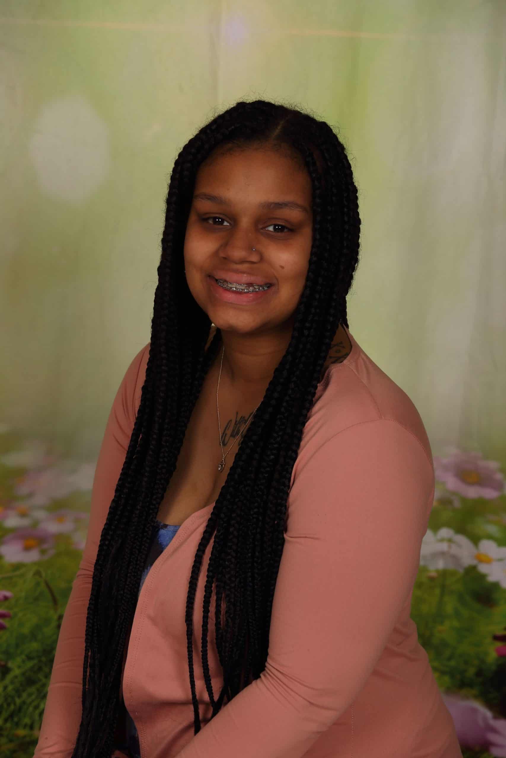 Photo of Co-Teacher Jaida Pro. She is a a young African-American woman with long hair. She is smiling and wears a pink sweater.