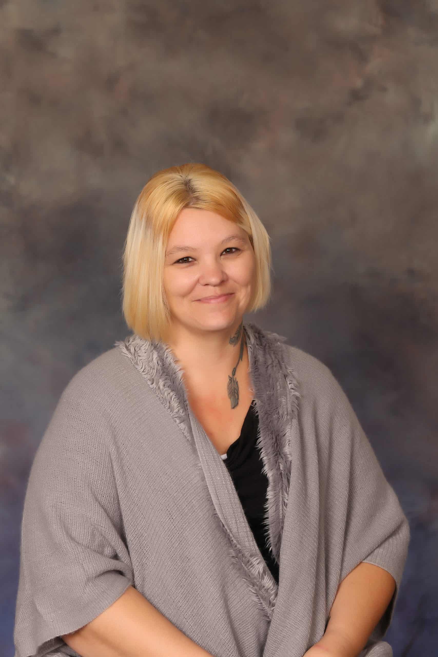 Photo of Lead Teacher Rhonda Coleman. She is a Caucasian woman with blonde hair, and wears a black shirt and gray shawl.